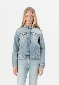Light blue denim jacket with a classic design, button closure, two chest pockets, and a slightly faded texture. Features a collar and long sleeves.
