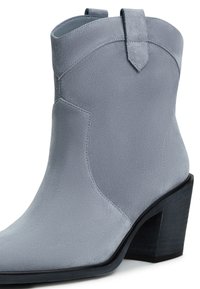 Grau Wildleder Stiefelette mit konischer Form, glatter Textur und Blockabsatz. Verfügt über eine Zuglasche und gestickte Details im oberen Bereich.