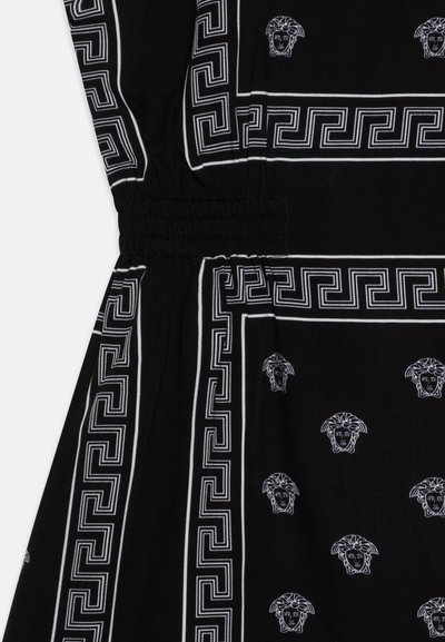 Juodas audinys su baltais graikų rakto dizaino kraštais ir pakartotiniais Medūzos galvos motyvais, su susiraukšlėjusia elastine detale ties liemeniu.