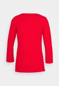 Rotes Langarmshirt mit rundem Ausschnitt. Glatte Baumwolltextur und leicht lockere Passform, mit mittellangen Ärmeln und ohne sichtbare Nähte.