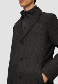 Wollmischung, dunkelgrauer Mantel mit strukturiertem Muster, leicht geknickten Revers und drei schwarzen Knöpfen. Die innere Schicht verfügt über ein gepolstertes Design mit Reißverschluss.