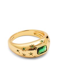 Guldpläterad ring med en stor smaragdformad grön sten, omgiven av små gröna stjärnformade detaljer. Slät, glänsande yta.