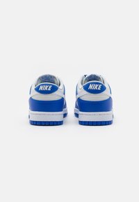 Nike sneakers with a blue and white color scheme, featuring smooth leather, a padded collar, and prominent heel branding. Rubber outsole details visible.