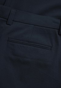 Granatowe spodnie wykonane z miękkiego materiału, o gładkiej fakturze, z płaskim przodem i tylną kieszenią z obszyciem.