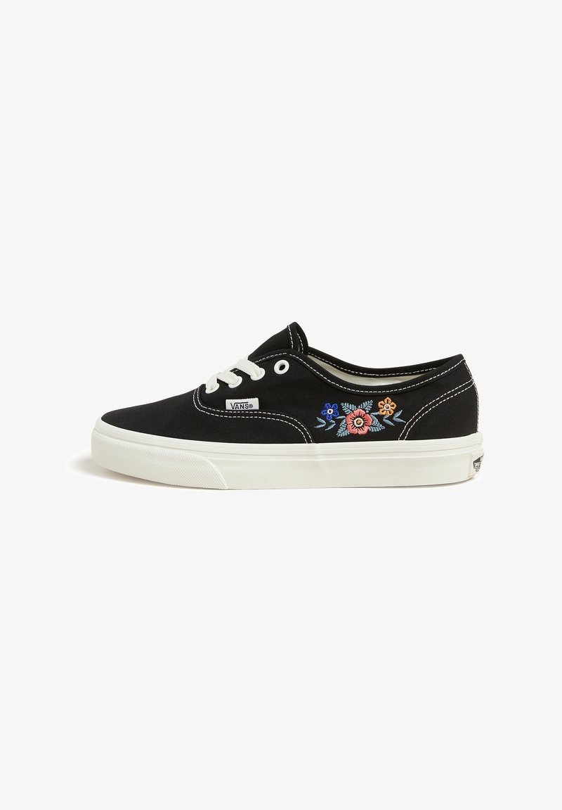 Baskets Vans noires avec lacets blancs, semelle blanche et motif floral brodé bleu, rose et orange sur le côté.
