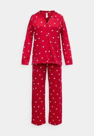 Rød pyjamas sæt lavet af blødt stof. Har lange ærmer, en knaplukket top, og bukser med hvide hjerte mønstre overalt.