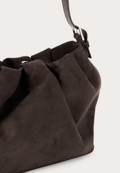 Borsa a tracolla in suede marrone con una superficie morbida e testurizzata, caratterizzata da un design attorcigliato e un dettaglio in metallo sull'imbragatura regolabile.