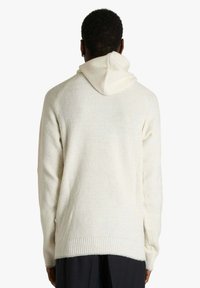 Felpa con cappuccio in avorio, con texture a coste, maniche lunghe e orlo posteriore leggermente allungato. Design semplice con accenti minimalisti.