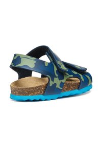 Sandalias con diseño de camuflaje, suela de goma azul, plantilla de corcho y correas de Velcro ajustables, con orificios para transpirabilidad.