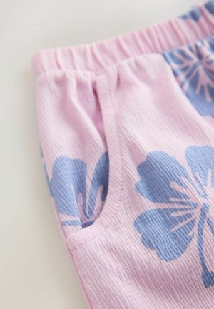 Shorts en tissu rose avec une surface texturée à motifs floraux bleus et une ceinture élastique. Comprend des poches sur les côtés.