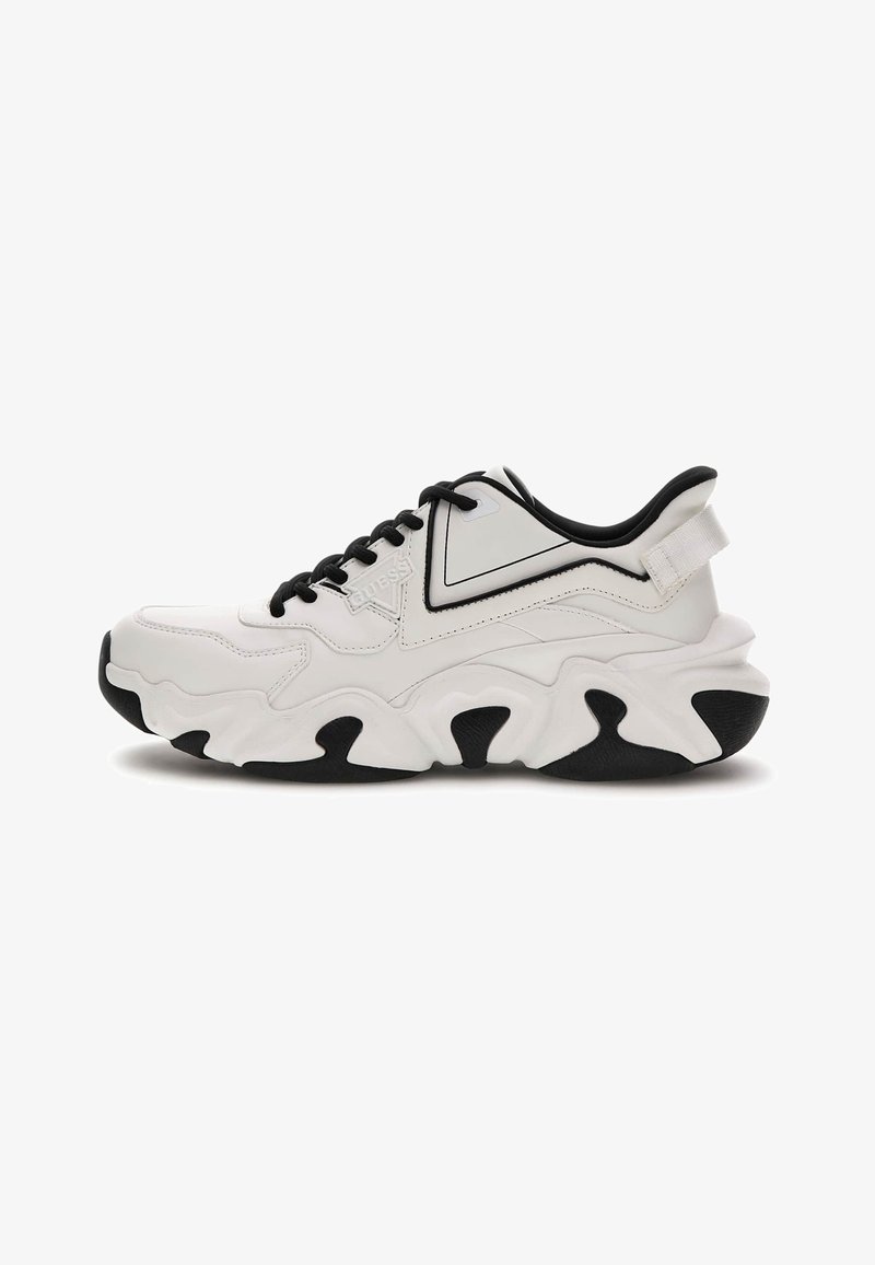 Bijela i crna chunky tenisica s debelim potplatom, crnim vezicama i petnom petljom, bočni logo "GUESS" na glatkom gornjem materijalu.