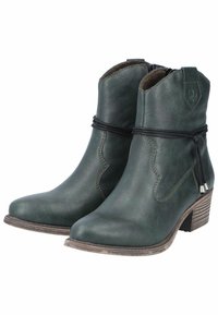 Botas de cuero verde hasta el tobillo con punta afilada, costuras curvas, cremallera lateral y un tacón de bloque texturizado. Decoradas con una correa de lazo ornamental.