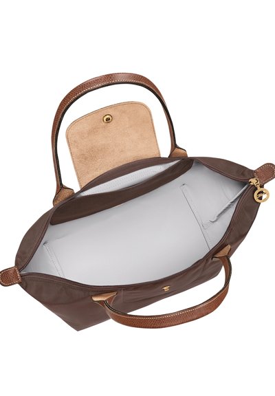 Brown leather handbag with double handles, open top showing light gray interior and small pockets inside.