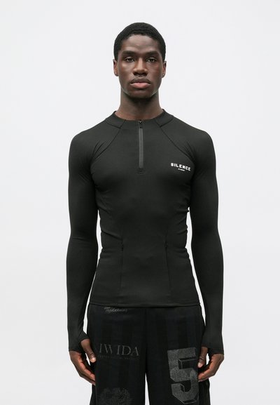 Black long-sleeve performance shirt with a zip collar and "SILENCE" text on the chest. Smooth fabric with a fitted design and minimal seams.