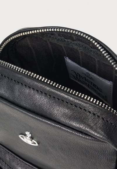 Černá kožená taška uvnitř, s uzavíráním na zip, texturovanou látkovou podšívkou a štítkem s nápisem "Vivienne Westwood".