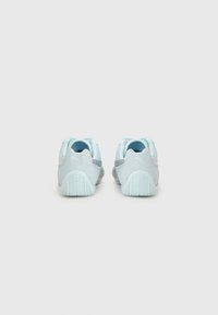 Light blue athletic shoes with a mesh upper and textured gray accents. Features a padded collar and detailed rubber outsole.