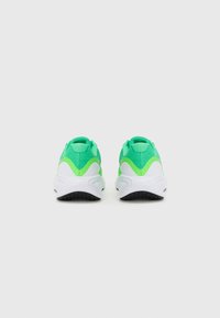 Zapatillas deportivas de malla verde y blanca con parte superior texturizada. Detalles de acento en verde brillante, suelas acolchadas y una suela de goma negra.