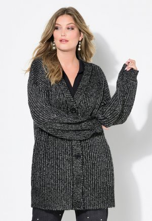 Cardigan texturé noir et blanc avec un col en V, coupe ample, manches surdimensionnées et cinq boutons sur le devant. Convient pour le superposition.