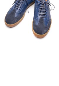Sneakers in pelle blu navy con dettagli in camoscio, punta rotonda e suola in gomma marrone chiaro; presentano lacci piatti e pannelli a contrasto.