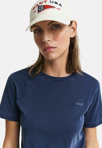 Marineblauwe katoenen t-shirt met korte mouwen en ronde hals; heeft een klein GANT-logo in het blauw geborduurd op de linkerkant van de borst.