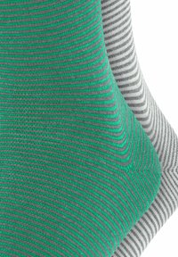 Drei Paar Socken: ein grünes Paar mit dünnen grauen Streifen, ein graues Paar mit dunklen Streifen und ein hellgraues Paar mit feinen horizontalen Linien. Weicher Stoff.