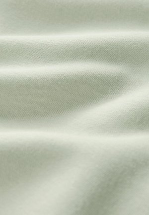 Weicher, hellgrüner Stoff mit feiner Strickstruktur und sanften Falten, die subtile Schatten und Highlights erzeugen.