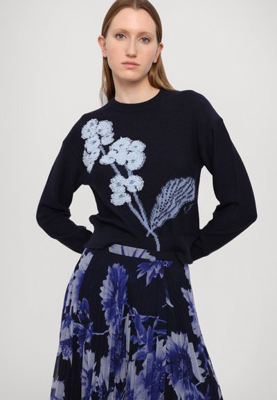 Navy sweater with light blue floral embroidery, crew neck, ribbed cuffs; paired with a pleated skirt featuring a dark blue floral pattern.