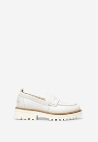 Mocassins en cuir blanc avec une semelle en caoutchouc blanc épaisse et texturée. Présente une couture à l'avant et une sangle décorative sur le dessus.