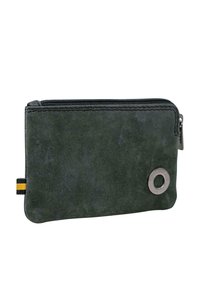 Cartera con cremallera en ante verde oscuro de textura suave. Cuenta con un adorno metálico redondo y un lazo de tela a rayas. Forma rectangular compacta.
