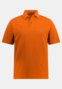 Oranssi polo-paita, joka on valmistettu kiinteästä kankaasta. Siinä on kaulus, jossa on kaksi nappia, ja rinnassa on pieni logo kontrastivärillä.