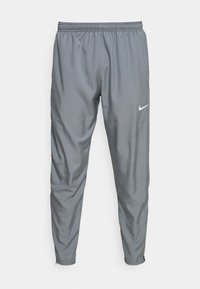 Graue Nike Sporthosen mit elastischem Bund und weißem Swoosh-Logo auf dem rechten Oberschenkel, schmal zulaufende Beine mit elastischen Bündchen.