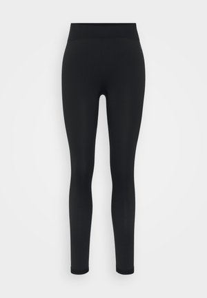 Svart leggings med en jevn tekstur. Høy midje og tettsittende design, med et mesh-mønster langs de nedre bena for pusteevne.