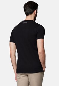 Czarny, krótki T-shirt z miękkiej bawełny, z okrągłym dekoltem, minimalistycznym wzorem i kontrastowym przeszyciem na rękawach.