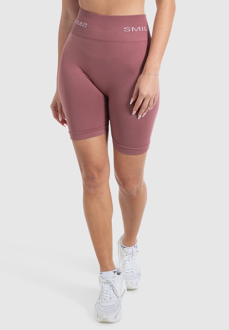 Pantaloni da bici aderenti a vita alta di colore rosa polveroso, realizzati in tessuto elasticizzato con una texture liscia; presentano una vita con logo a contrasto.