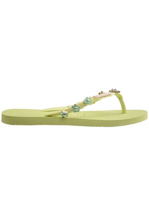 Sandale din cauciuc verde, cu talpă texturată, având accente florale și accesorii metalice pe brățara de tip thong. Toc plat, design casual.