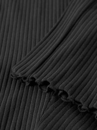 Black ribbed fabric with a textured surface. Features softly scalloped edges, creating a delicate finish. Suitable for various clothing styles.