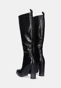 Botas de cuero negro hasta la rodilla con textura de cocodrilo, cierre de cremallera lateral y tacones gruesos y altos. Acabado suave con un aspecto brillante.