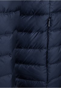 Giacca puffy blu navy con pannelli trapuntati, caratterizzata da una texture liscia e lucida, tasca con zip e coulisse elastica all'orlo.