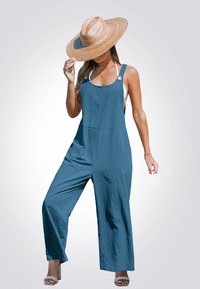 Tuta blu con gambe larghe, realizzata in tessuto leggero, caratterizzata da spalline regolabili e bottoni rotondi. Indossata con un cappello di paglia a tesa larga.