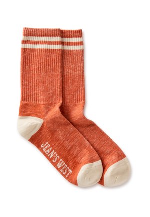 Par de calcetines naranja con costillas, con rayas blancas en la punta, el talón y el puño, y el texto "JEAN'S WEST" en la suela.