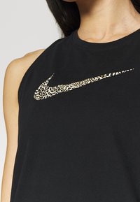 Top atletico senza maniche di colore nero con logo Nike a stampa leopardata. Realizzato in morbido cotone, presenta un collo rotondo e un design con spalle scoperte.