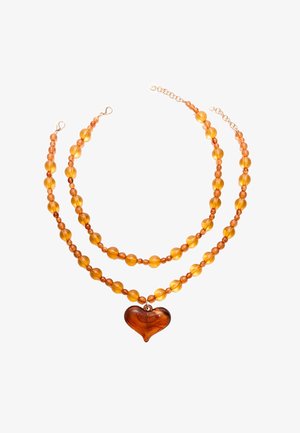 Twee-laags ketting met amberkleurige kraaltjes van verschillende maten, met een grote hartvormige hanger in het midden. Vergulde sluiting en kettingaccenten.