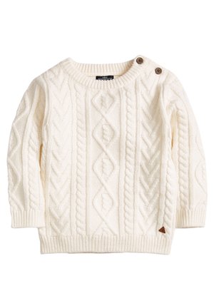 Roomkleurige kabelgebreide trui met lange mouwen en twee bruine knopen op de linker schouder, geribbelde manchetten en zoom.