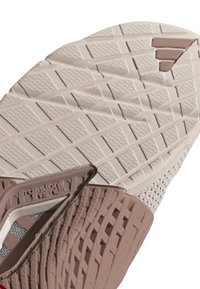 Suola di sneakers leggero in beige con motivi di trazione testurizzati. Presenta un elemento di supporto del Torsion System in tonalità più scure.