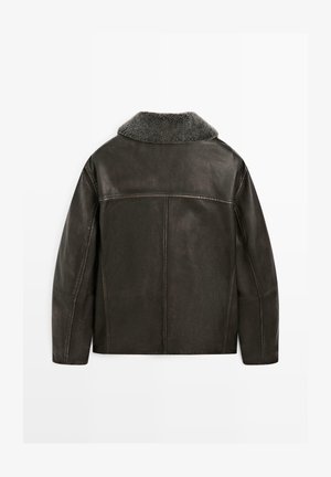 Brązowa skórzana kurtka z kołnierzem z owczej wełny, o gładkiej fakturze i prostych przeszyciach na plecach.