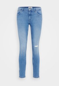 Jeans ajustados de denim azul claro con una rodilla desgastada. Presentan una cintura de altura media y cremalleras en los tobillos para un estilo entallado.