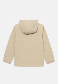 Veste à capuche beige avec une texture lisse, des manches longues et une silhouette droite. Elle présente un empiècement à l'arrière et des détails de couture.