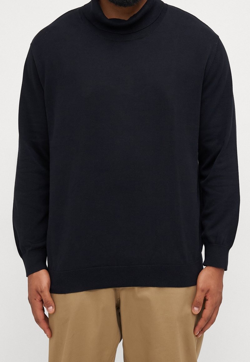 Pull à col roulé bleu marine foncé, fabriqué en tissu doux, doté de poignets et d'un ourlet côtelés, avec une coupe décontractée et un design sans coutures.