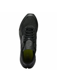 Scarpa da atletica nera con tomaia strutturata, punta rotonda, design con lacci, linguetta imbottita e soletta imbottita con dettaglio verde.
