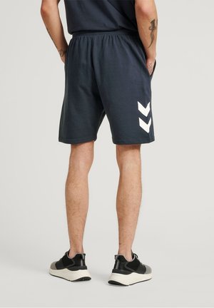 Shorts in cotone blu navy con vita elastica, caratterizzati da accenti a zigzag bianchi sui lati. Design morbido, ideale per un look casual.